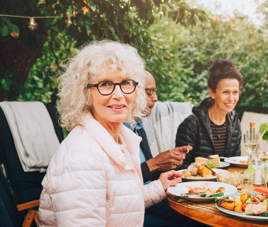 Mensen zitten buiten aan een tafel/