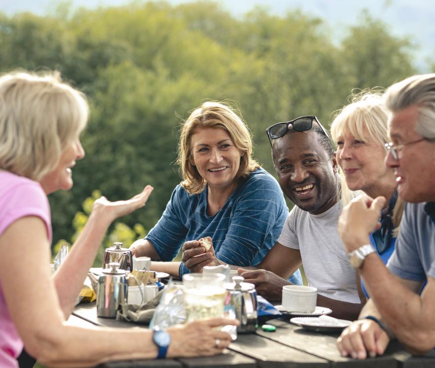 Mensen zitten buiten aan tafel te praten